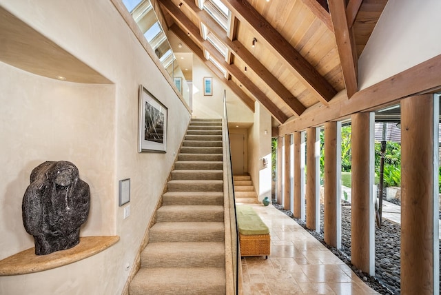 stairs with beam ceiling, wood ceiling, and high vaulted ceiling