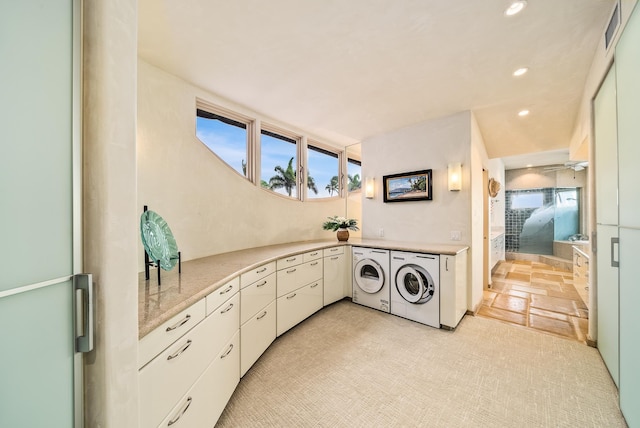 laundry room with washer and dryer and cabinets