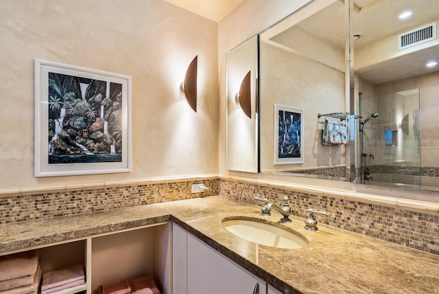 bathroom featuring decorative backsplash, vanity, and tiled shower