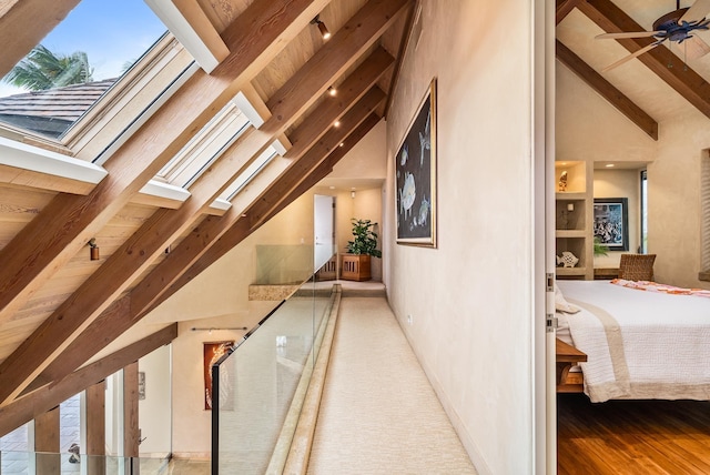 hall featuring beamed ceiling, hardwood / wood-style flooring, and high vaulted ceiling