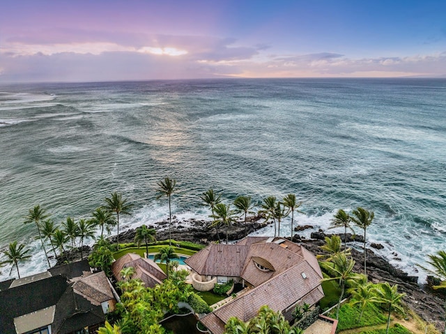 aerial view at dusk featuring a water view