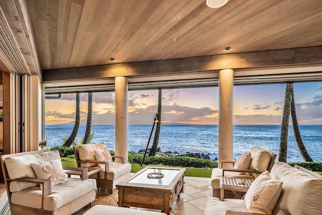 sunroom / solarium featuring a water view and wood ceiling