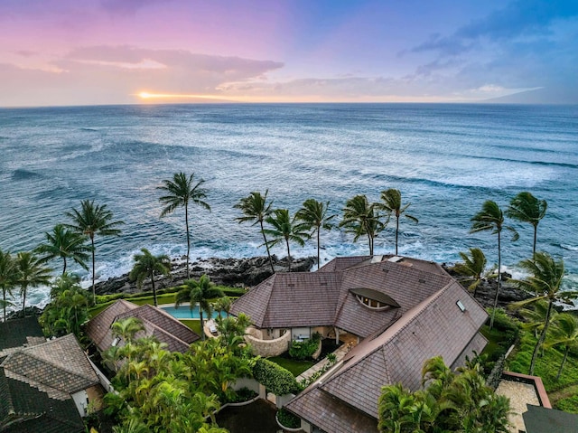 aerial view at dusk featuring a water view