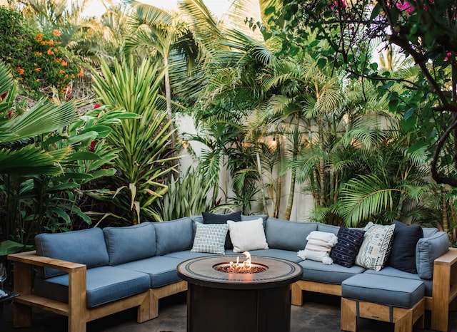 view of patio with an outdoor living space with a fire pit