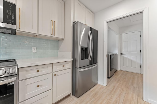 1395 Hiahia St, Wailuku, HI 96793 - kitchen featuring appliances with stainless steel finishes, decorative backsplash, washer and dryer, light wood-style floors, and white cabinets