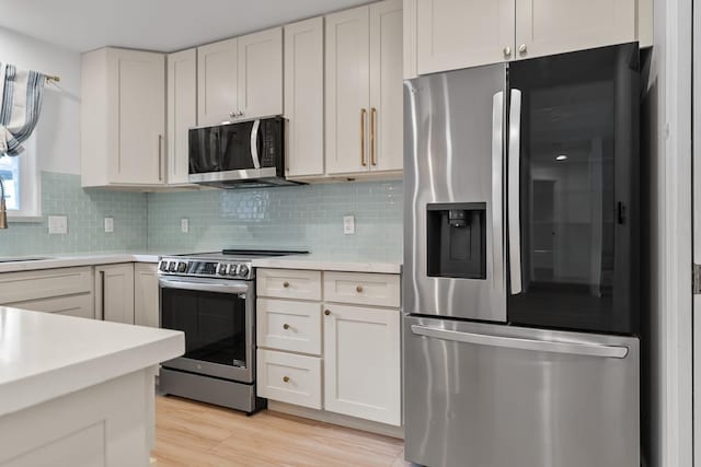 1395 Hiahia St, Wailuku, HI 96793 - kitchen featuring stainless steel appliances, light countertops, tasteful backsplash, light wood-style floors, and white cabinets