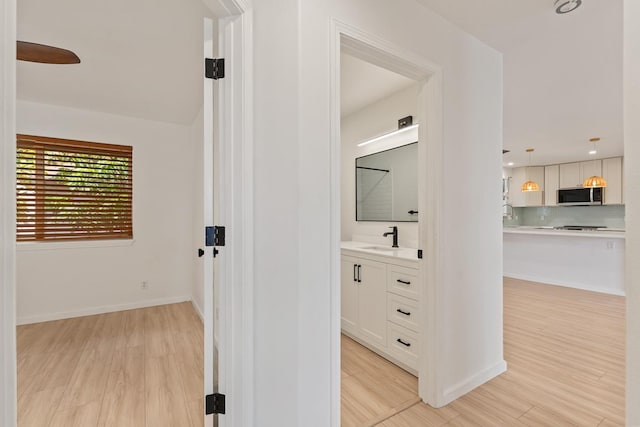 1395 Hiahia St, Wailuku, HI 96793 - hall with light wood-style floors, a sink, and baseboards