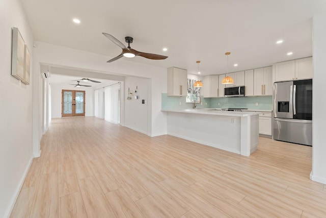 1395 Hiahia St, Wailuku, HI 96793 - kitchen featuring appliances with stainless steel finishes, open floor plan, light countertops, backsplash, and a ceiling fan