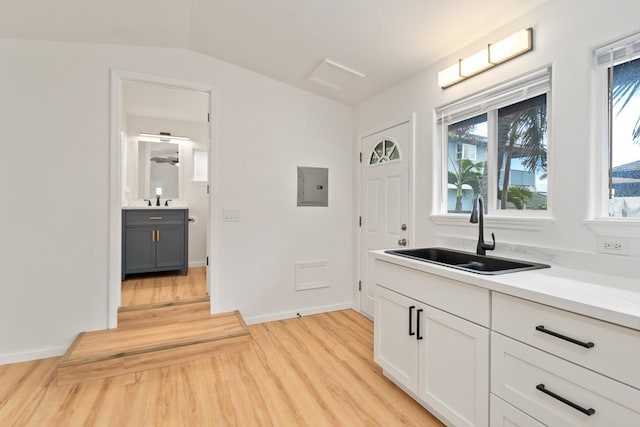 1395 Hiahia St, Wailuku, HI 96793 - kitchen with a sink, light wood-style flooring, electric panel, light countertops, and white cabinets