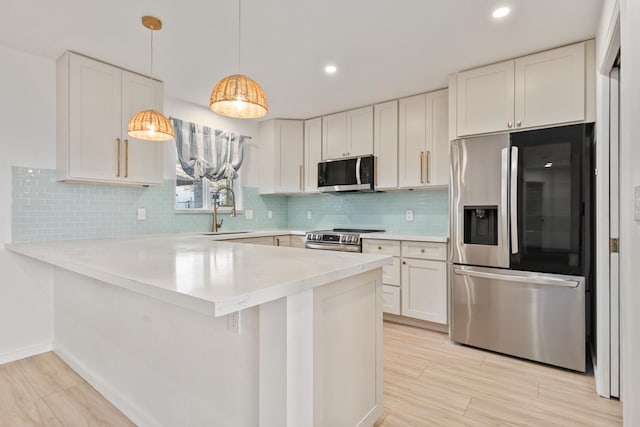 1395 Hiahia St, Wailuku, HI 96793 - kitchen featuring stainless steel appliances, a sink, a peninsula, light countertops, and white cabinetry