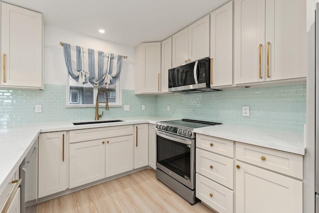 1395 Hiahia St, Wailuku, HI 96793 - kitchen featuring stainless steel range with electric cooktop, a sink, white cabinetry, light wood-style flooring, and recessed lighting