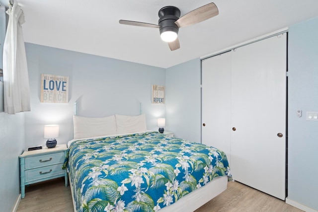 bedroom with light hardwood / wood-style flooring, ceiling fan, and a closet