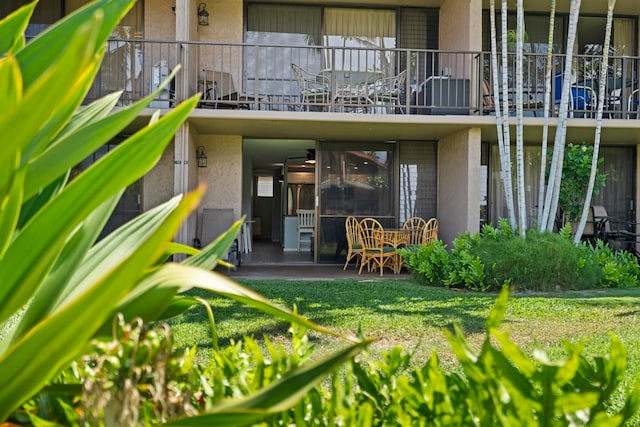 exterior space featuring a balcony, a patio, and a yard