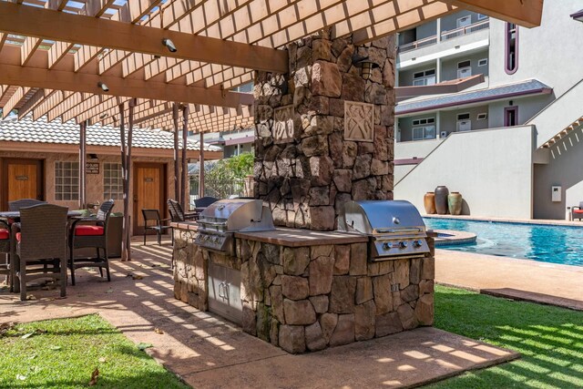 view of patio with a pergola, area for grilling, and an outdoor kitchen