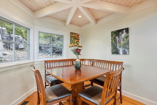 dining space featuring beamed ceiling, wood-type flooring, and wood ceiling
