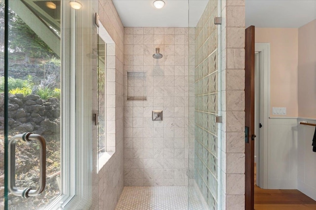 bathroom with hardwood / wood-style floors, a wealth of natural light, and tiled shower