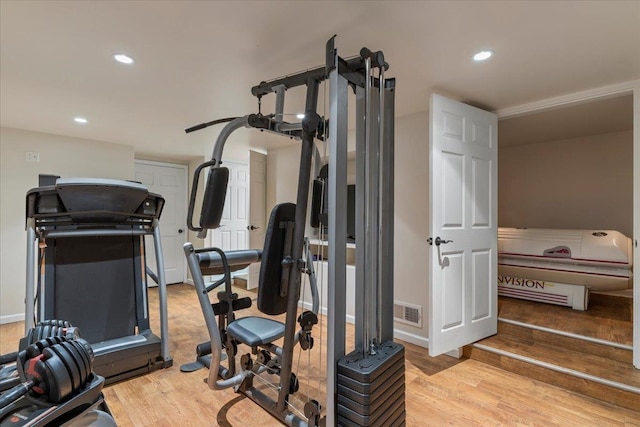 exercise room with light hardwood / wood-style floors