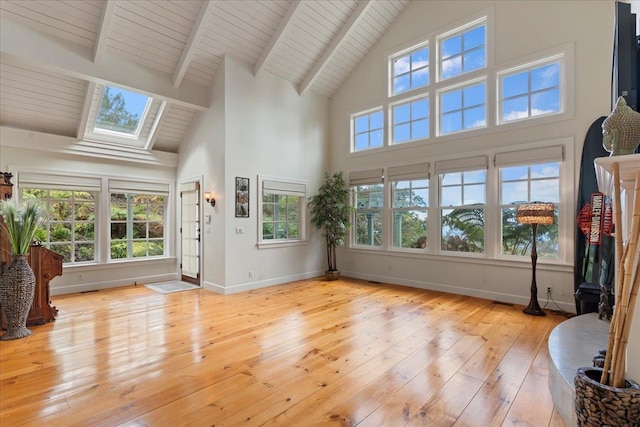 sunroom featuring lofted ceiling with skylight and wooden ceiling