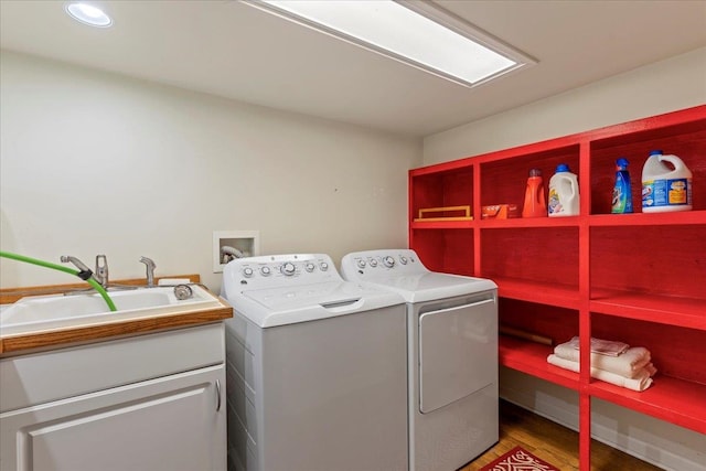 washroom with dark wood-type flooring, cabinets, sink, and washing machine and clothes dryer