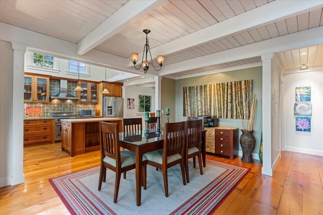 dining area featuring light hardwood / wood-style flooring, beamed ceiling, wood ceiling, and an inviting chandelier