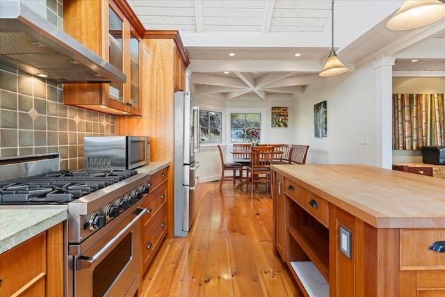 kitchen featuring light hardwood / wood-style floors, wall chimney exhaust hood, hanging light fixtures, beam ceiling, and appliances with stainless steel finishes