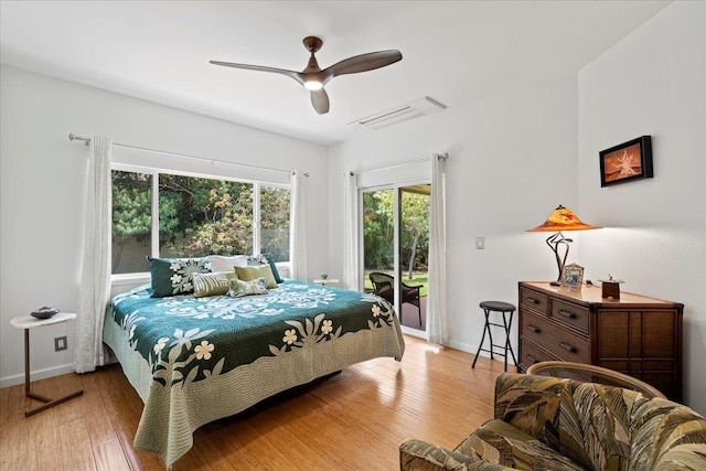 bedroom featuring visible vents, wood finished floors, baseboards, access to outside, and a ceiling fan