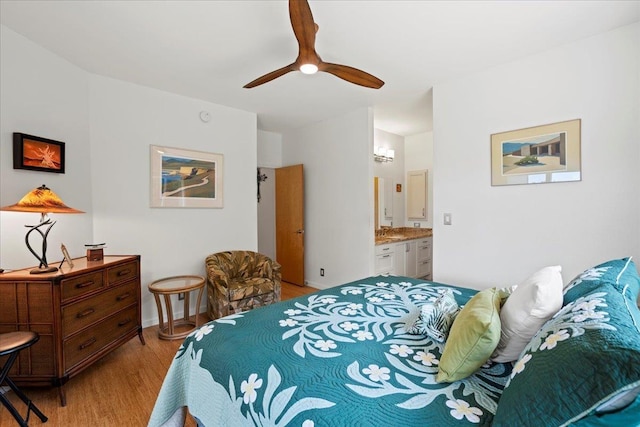 bedroom featuring a ceiling fan, light wood finished floors, and ensuite bath