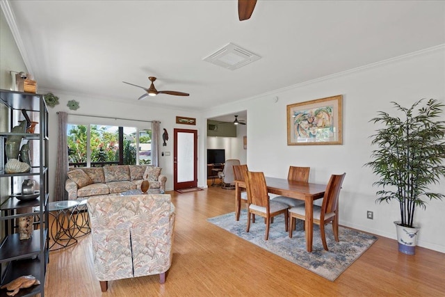 living room with ceiling fan, ornamental molding, wood finished floors, and visible vents