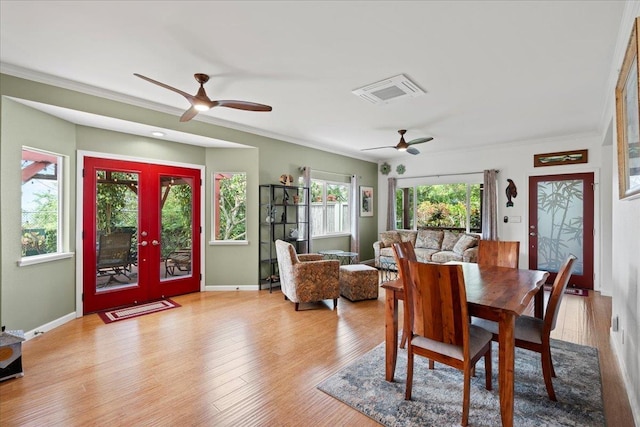 dining room featuring crown molding, a ceiling fan, baseboards, and wood finished floors