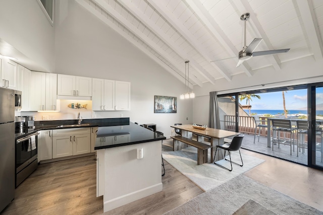 kitchen featuring white cabinetry, light hardwood / wood-style flooring, beamed ceiling, and a water view