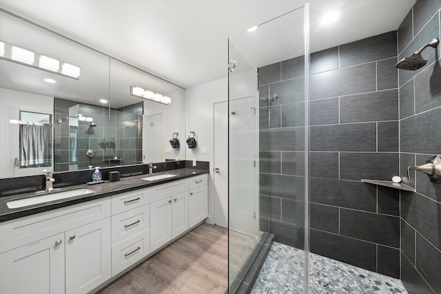 bathroom with a tile shower, vanity, and hardwood / wood-style flooring