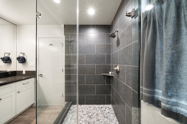 bathroom featuring a tile shower and vanity