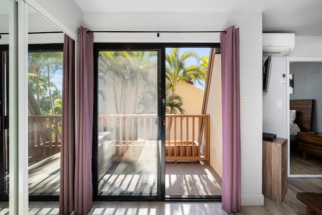 doorway with hardwood / wood-style floors, a wealth of natural light, and an AC wall unit