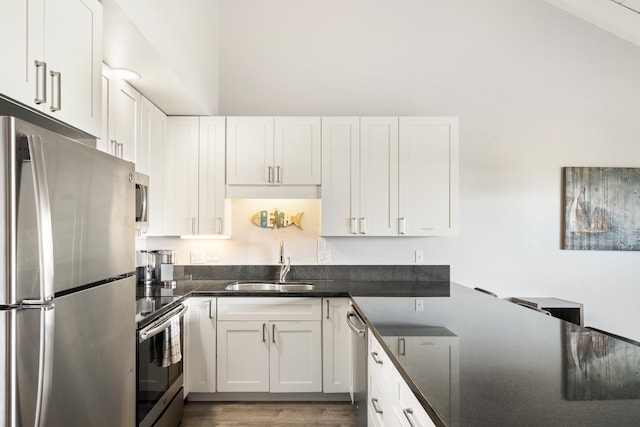 kitchen featuring stainless steel appliances, white cabinets, sink, and light hardwood / wood-style flooring