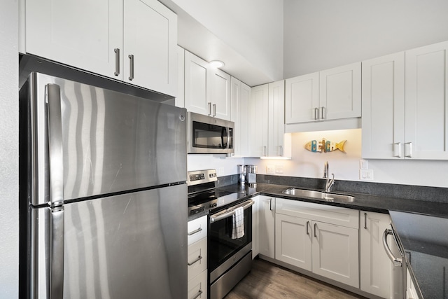 kitchen featuring appliances with stainless steel finishes, white cabinets, and sink