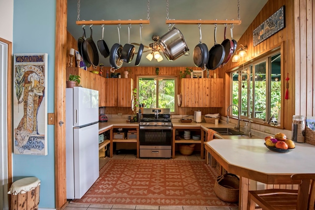 kitchen with stove, white refrigerator, sink, and a wealth of natural light