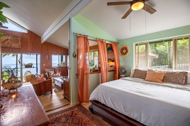 bedroom with ceiling fan, hardwood / wood-style floors, lofted ceiling with beams, and wooden walls