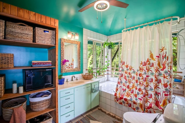 bathroom featuring toilet, walk in shower, tile walls, tile patterned flooring, and vanity