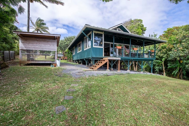 rear view of property featuring a wooden deck and a yard