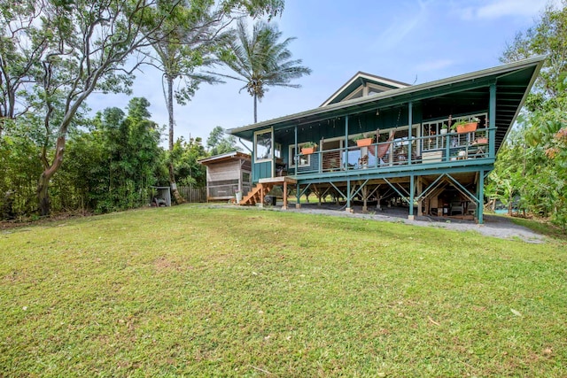 rear view of property with a wooden deck and a yard