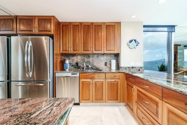 kitchen with stone counters, sink, stainless steel appliances, tasteful backsplash, and light tile patterned flooring