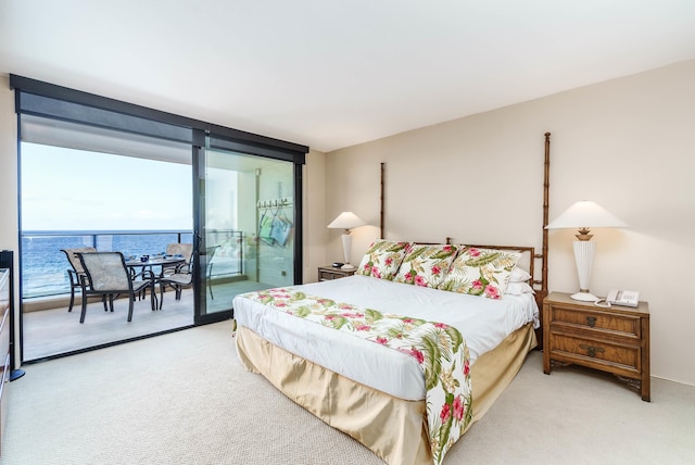 carpeted bedroom featuring expansive windows, a water view, and access to outside