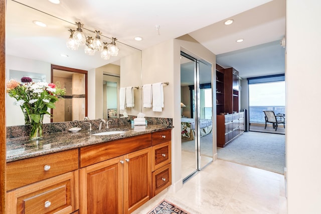 bathroom with vanity, a water view, and expansive windows