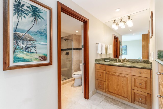 bathroom featuring vanity, a shower with shower door, and toilet