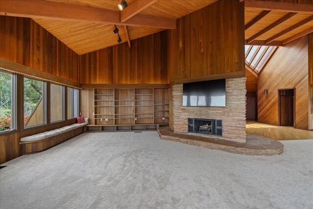 2450 Piiholo Rd, Makawao, HI 96768 - unfurnished living room featuring high vaulted ceiling, wood walls, wood ceiling with exposed beams, carpet floors, and a stone fireplace