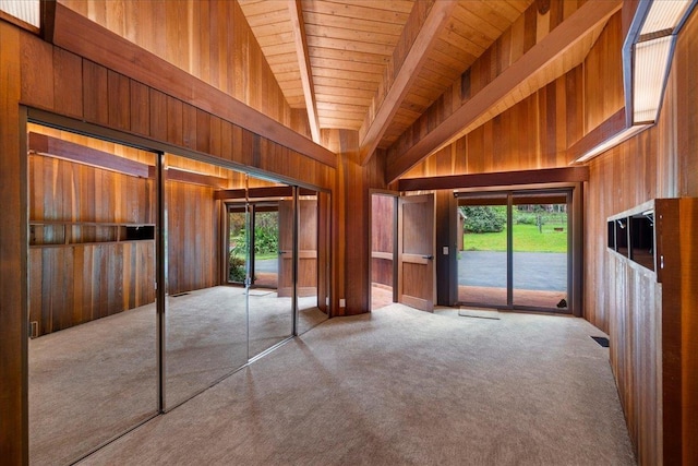 2450 Piiholo Rd, Makawao, HI 96768 - unfurnished bedroom featuring wood walls, wooden ceiling with exposed beams, access to outside, multiple windows, and carpet flooring