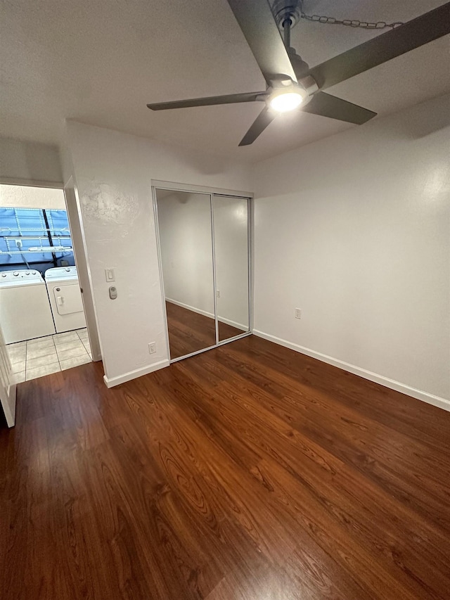 unfurnished bedroom with dark hardwood / wood-style floors, ceiling fan, washer and dryer, a textured ceiling, and a closet