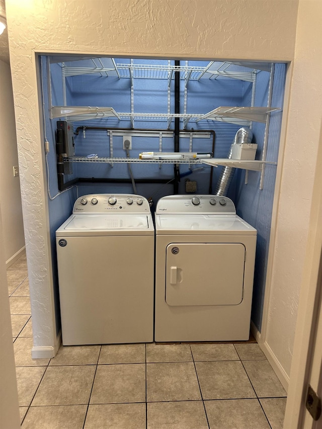 clothes washing area with light tile patterned flooring and independent washer and dryer