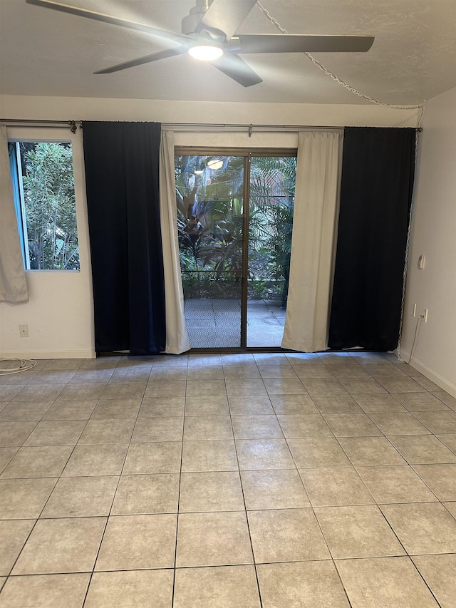 empty room featuring ceiling fan and light tile patterned floors