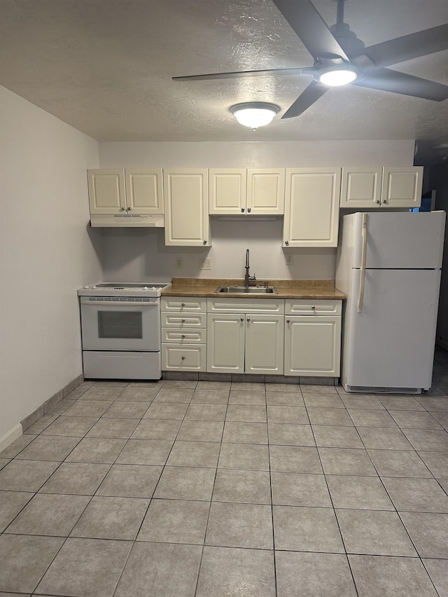 kitchen featuring a textured ceiling, light tile patterned flooring, white appliances, and sink